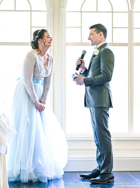 istock Bride and groom make speeches with microphone on their wedding day at the reception 1324299365