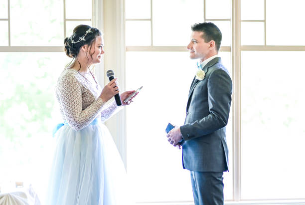 istock Bride and groom make speeches with microphone on their wedding day at the reception 1324299374