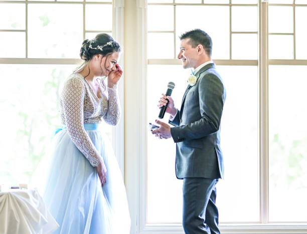 Bride and groom make speeches with microphone on their wedding day at the reception