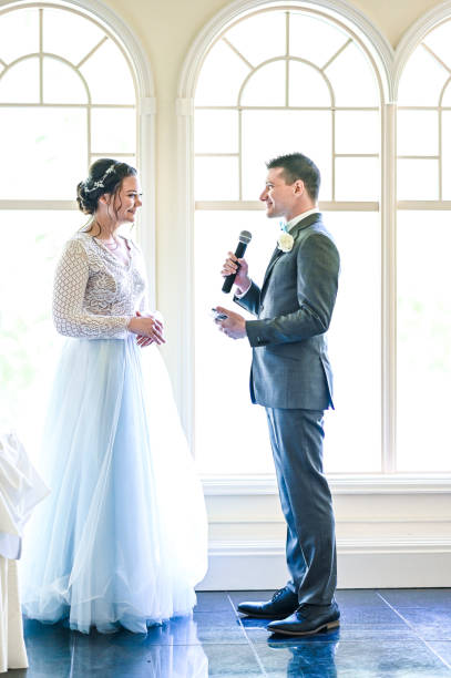 istock Bride and groom make speeches with microphone on their wedding day at the reception 1324300236