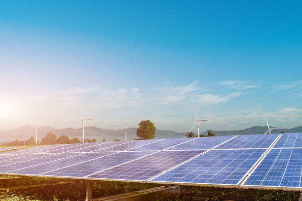 istock Solar panels with wind turbines generating electricity at sunset background. 1324310005