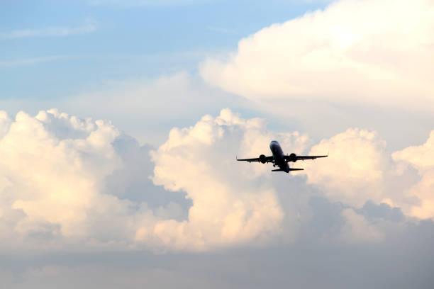 istock Airplane taking off from the runway between the blue sky with big clouds 1324310165