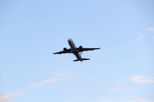istock Airplane taking off from the runway between the blue sky with big clouds 1324310171