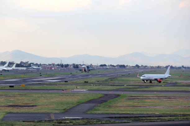 istock Airplane taking off from the runway between the blue sky with big clouds 1324310904