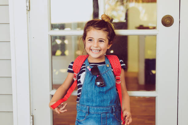cute little girl wearing backpack headed to her very first day of school - first day of school imagens e fotografias de stock