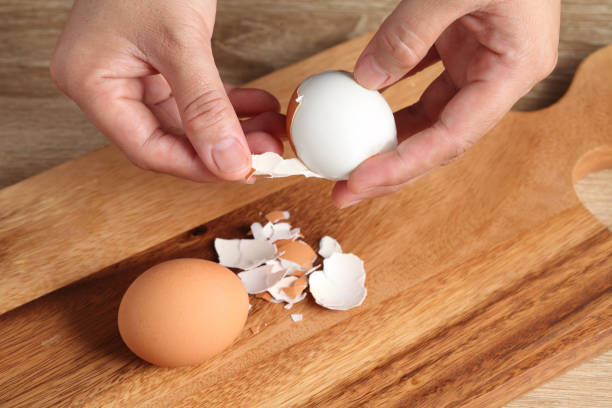 istock Chef peeling boiled egg on wooden cutting board in kitchen 1324314914