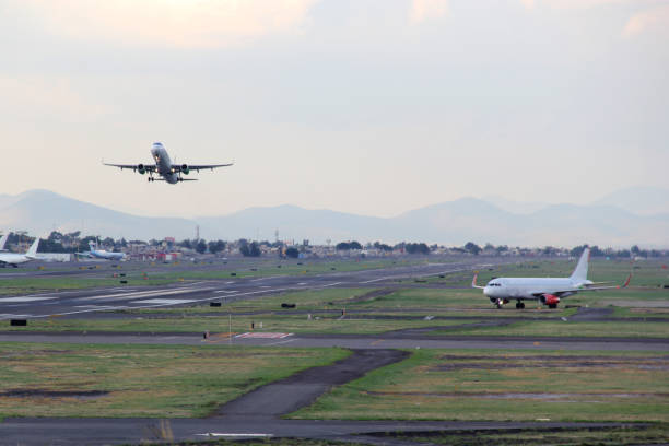istock Airplane taking off from the runway between the blue sky with big clouds 1324318910