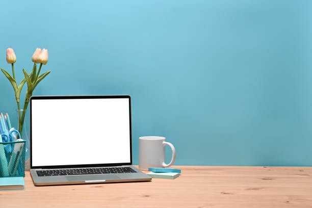 istock Mock up laptop computer, pencil holder and coffee cup on stylish workspace. 1324319139