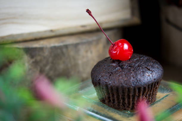 cupcakes de chocolate em um prato de vidro, atmosfera de verão, dia quente, conceito de estilo de vida. - cupcake crumb sweet wrapper chocolate - fotografias e filmes do acervo