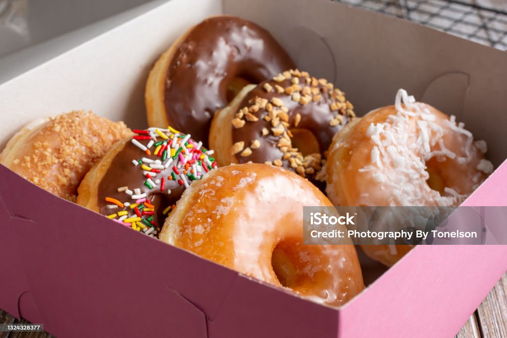 pink box, donuts A view of a pink box filled with a half dozen favorite donut varieties. Doughnut Stock Photo