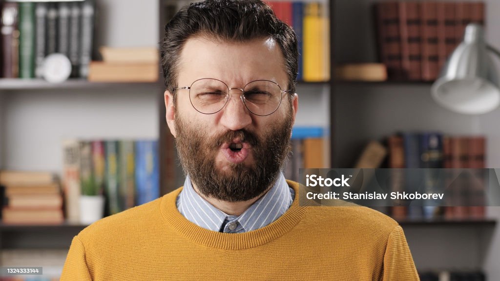Man disgust, abomination, FU, auch emotion. Bearded male teacher or businessman with glasses looking at camera and his face is distorted in disgust Man disgust, abomination, FU, auch emotion. Bearded male teacher or businessman with glasses looking at camera and his face is distorted in disgust. Medium shot Men Stock Photo