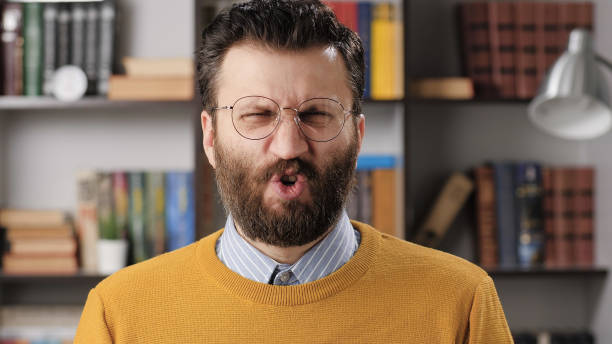 Man disgust, abomination, FU, auch emotion. Bearded male teacher or businessman with glasses looking at camera and his face is distorted in disgust Man disgust, abomination, FU, auch emotion. Bearded male teacher or businessman with glasses looking at camera and his face is distorted in disgust. Medium shot grimacing stock pictures, royalty-free photos & images