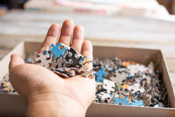 hand holds puzzle pieces stock photo