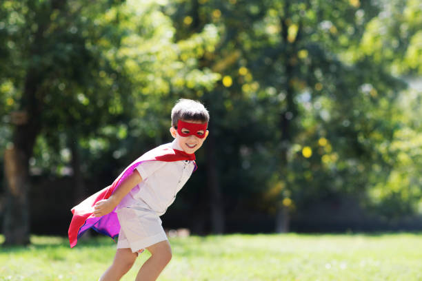 istock Child boy  in Superhero costume playing background nature. Copyspace. 1324333459