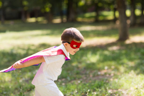istock Child boy  in Superhero costume playing background nature. Copyspace. 1324333460