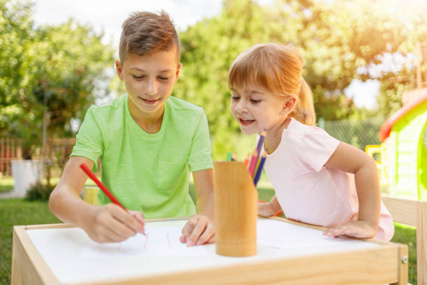 istock Girl looking at her brother drawing 1324338442