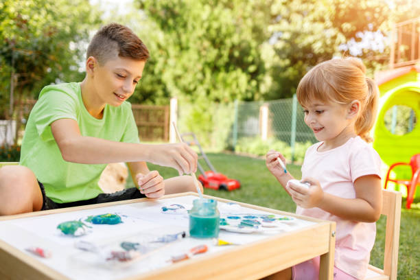 istock Siblings using watercolors outdoors 1324338445