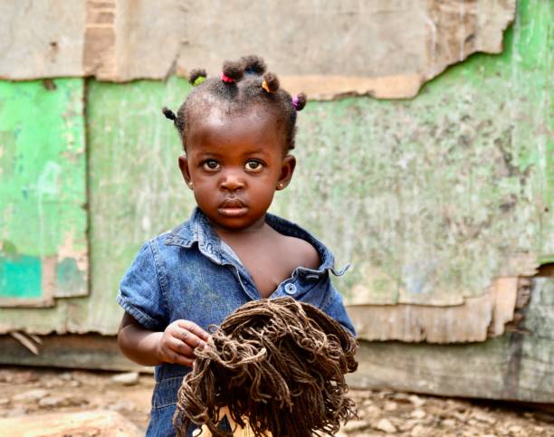 Portrait Of A Little Girl With A Doll Photo taken in Accra, Ghana child ghana poverty africa stock pictures, royalty-free photos & images