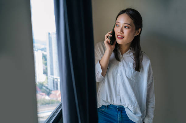 istock Beautiful young Asian woman using smartphone and smiling 1324343562