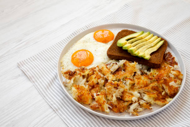 sabrosos hashbrowns fritos caseros y huevos en un plato, vista lateral. espacio de copia. - hash brown gold food vegetable fotografías e imágenes de stock