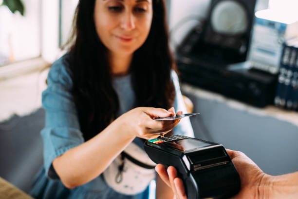 mujer que realiza pagos sin contacto con tarjeta de crédito - credit cards fotografías e imágenes de stock