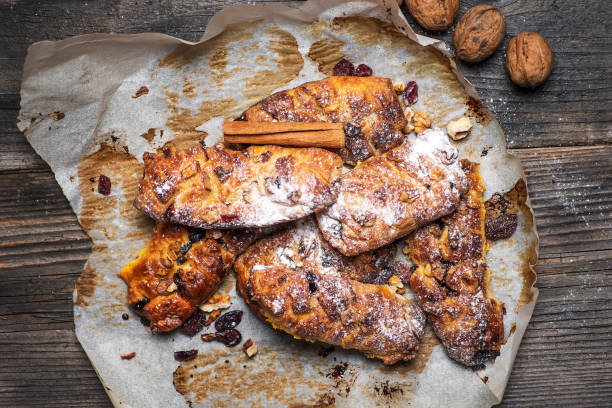 Homemade sweet pie with walnuts and dried cranberry fruits on a rustic wooden table