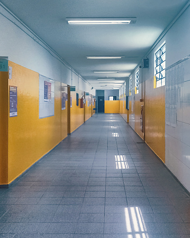An empty corridor of a Brazilian school, with white and yellow walls.