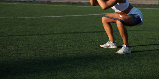 istock Strong woman doing squats with resistance band 1324347750