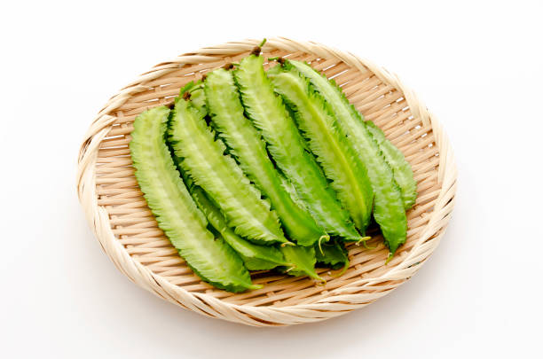istock Fresh Winged beans on a bamboo sieve on a white background 1324347825