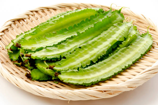 istock Fresh Winged beans on a bamboo sieve on a white background 1324347939