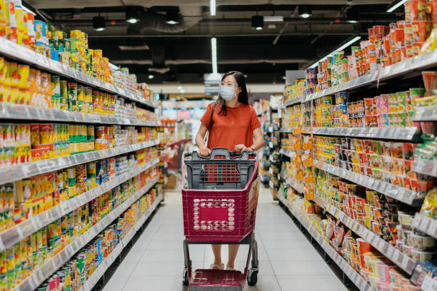 asiatische frau mit gesichtsmaske und gesichtsschild einkaufen für lebensmittel im supermarkt - aufwärmen stock-fotos und bilder