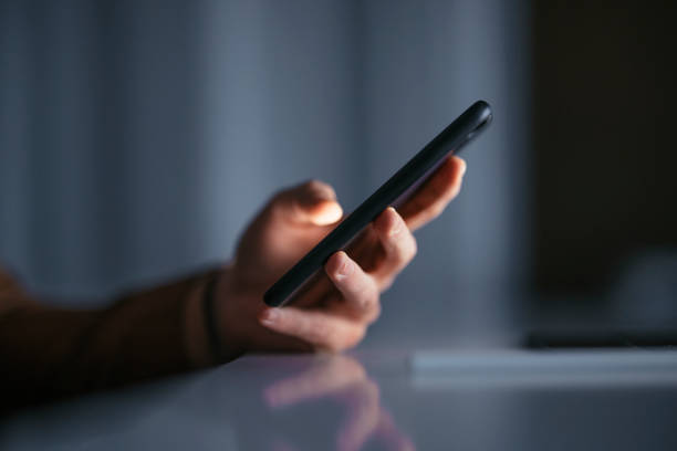 Late Night Work At Home: Unrecognizable Man Holding Mobile