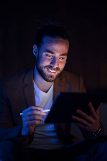 istock Late Night Work At Home: Smiling Businessman With Beard Holding Digital Pen 1324348244