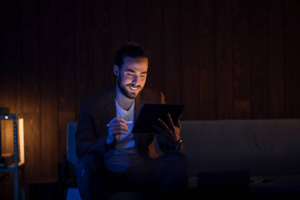 istock Late Night Work At Home: Handsome Businessman With Beard At Sofa Holding Pen 1324348266