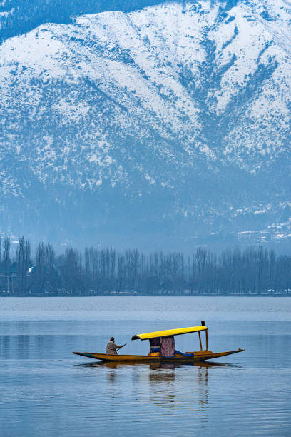 A beautiful view of Dal Lake in winter, Srinagar, Kashmir, India. A view of Dal Lake in winter, and the beautiful snowcapped mountain range in the background in the city of Srinagar, Kashmir, India. jammu and kashmir photos stock pictures, royalty-free photos & images