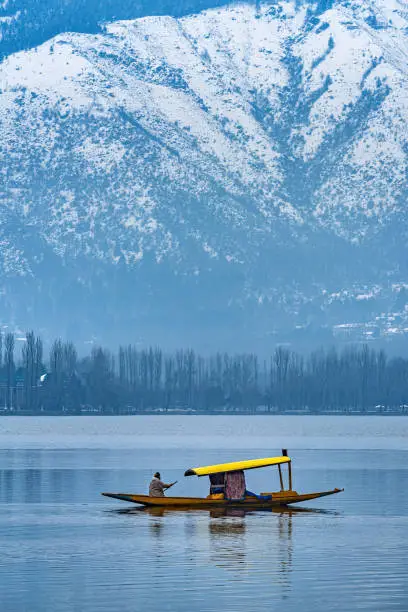 A view of Dal Lake in winter, and the beautiful snowcapped mountain range in the background in the city of Srinagar, Kashmir, India.