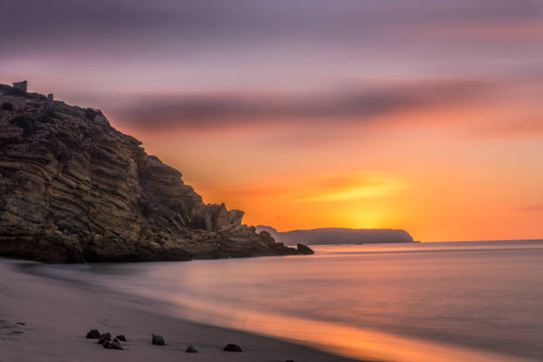 ciel coloré le matin avec du rocher avant le lever du soleil à praia da figueira, portugal - long exposure rock cloud sky photos et images de collection