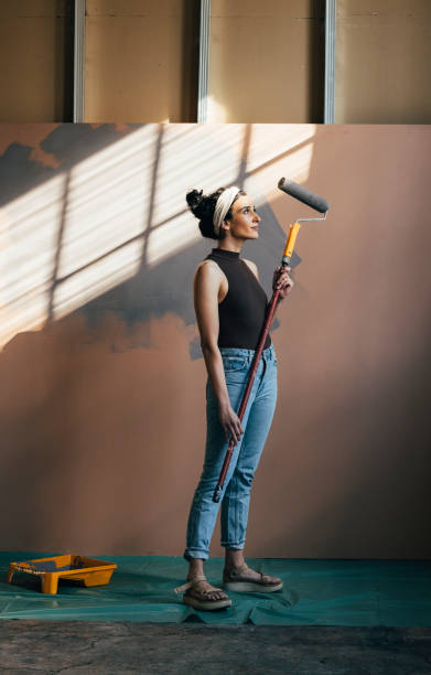 istock Happy Woman Posing With Paint Roller 1324350586