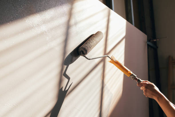 istock Female Hands Painting Panel with Paint Roller 1324350588