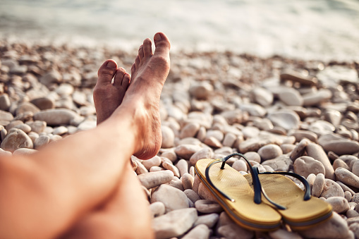 A pair of slippers on the gravel .