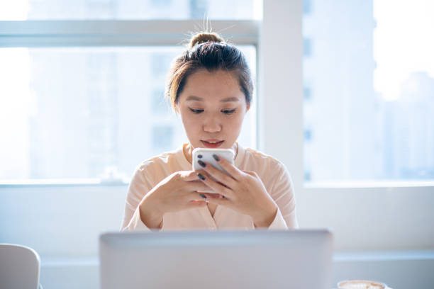 istock Businesswomen using phone in office 1324356755