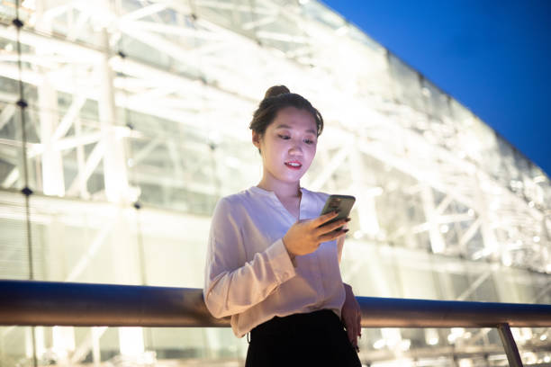 istock Young businesswomen using phone at night 1324358124