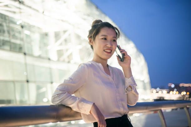 istock Young businesswomen talking on mobile phone at night 1324358144