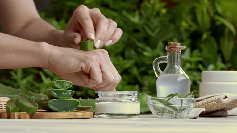 Panning shot of young woman moisturizing hands with aloe vera natural gel