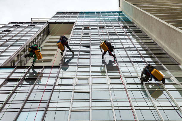 Industrial mountaineering workers hangs over residential facade building
