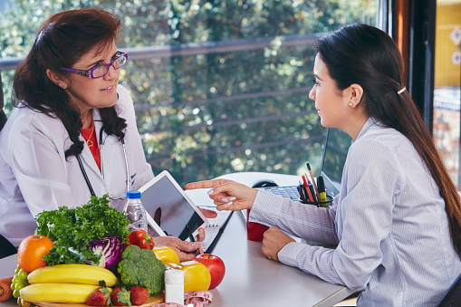 Nutrition dieting concepts. Nutritionist giving consultation to patient with healthy fruit and vegetable