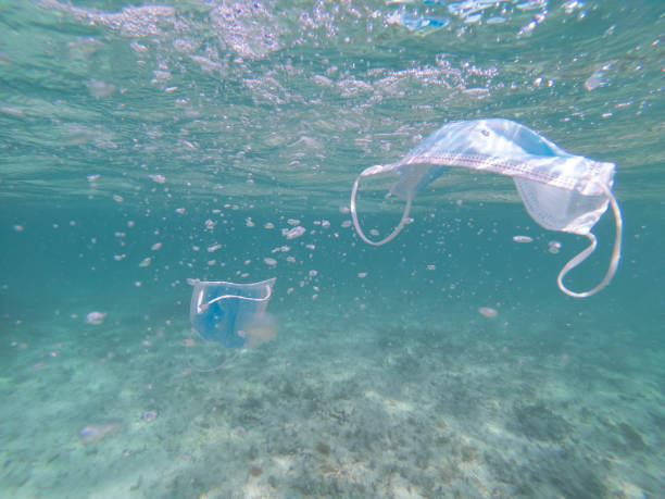 istock Protective face masks from coronavirus floating under water. Pollution of environment and ecological issue concept 1324367294