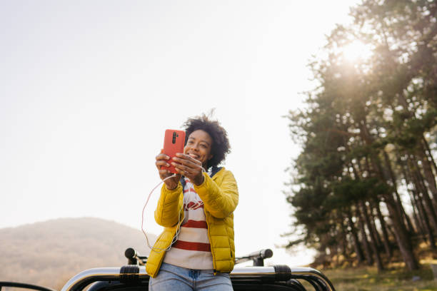 istock Young woman having a video call while on a road trip 1324374783