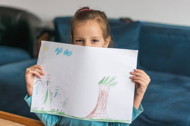 istock Child holding her drawing on a paper 1324376413