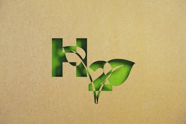 Cut out leaf shaped made of recycled paper intersect with Hydrogen symbol on green background. Horizontal composition with copy space. Sustainability concept.